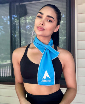 Woman wearing a blue Mr Cool cooling towel around her neck over a black sports bra