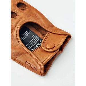 Hestra tan leather glove cuff with snap button and care label