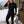 Woman wearing Gobi Heat black thermal base layer set standing on wooden deck with skis