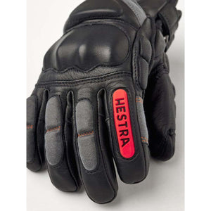 Hestra black leather ski glove with grey knuckle padding and red logo patch