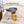 Person using a spatula to flip a burger patty on a BioLite CampStove steel grill attachment
