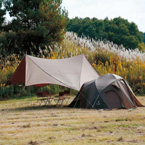 Snow Peak tent and tarp set with camping chairs and table in a field