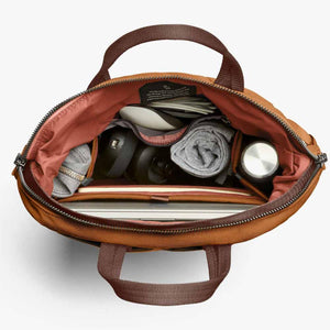 Top view of open Bellroy bag filled with laptop, water bottle, and personal accessories