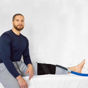 Man wearing a Polar Products knee therapy wrap with blue tubing attached