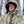 Man wearing Realtree camouflage hooded hunting suit and Heater Body Suit cap in a forest