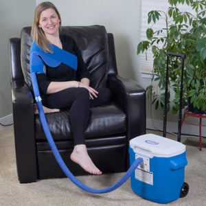 Woman wearing a Polar Products shoulder cold therapy wrap connected to a portable cooler