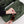 Person placing sunglasses into the interior zippered pocket of an olive green backpack