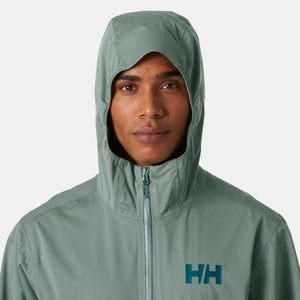Man wearing a sage green Helly Hansen hooded jacket with HH logo