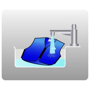 HyperKewl cooling vest being soaked in a sink under a running faucet