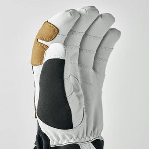 White leather glove with black fabric panel and tan leather thumb reinforcement