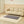 Grey quilted electric heating mat on a patterned rug in front of a beige sofa