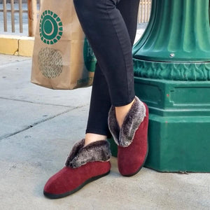 Acorn burgundy slippers with faux fur lining worn with black pants