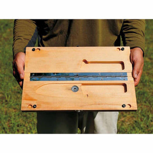 Person holding a folded wooden cutting board with a metal hinge