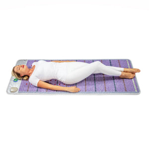 Woman lying on a purple acupressure mat with red nodes