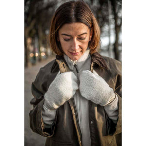 Woman wearing a brown wax jacket over a cream fleece and matching cream fleece mittens