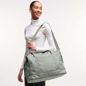 Person wearing a sage green Got Bag duffel bag over their shoulder