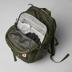 Open olive green Fjallraven backpack with internal mesh pockets containing cables and gloves