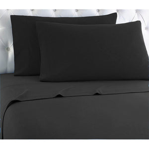 Two black pillowcases on a bed with a white tufted headboard