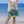 Person holding a folded Cgear sand free beach mat with a green and yellow pattern