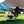 Person and child sitting in Snow Peak chairs by a campfire under a tarp