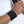 Person wearing a black terry cloth wristband while holding a gym weight