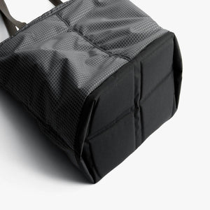 Base of a grey Bellroy tote bag with a grid pattern and reinforced black bottom panel
