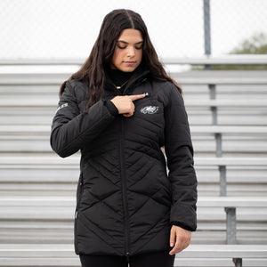 Person wearing black ActionHeat Philadelphia Eagles heated jacket pointing to the power button