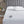 Serta heated mattress pad with two handheld controllers on a bed with a grey tufted headboard
