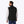 Man wearing a black Mobile Warming fleece vest over a grey long sleeve shirt from the back