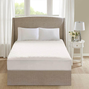 Beautyrest white quilted mattress pad on a bed with a beige headboard
