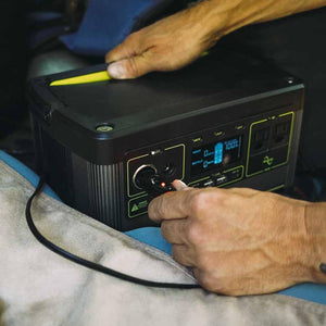 Person plugging a 12V car charger into a portable power station
