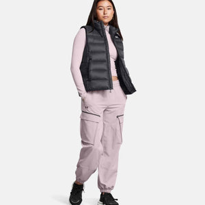 Under Armour model wearing a black puffer vest over a light pink long sleeve shirt and matching cargo joggers