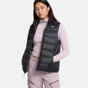 Woman wearing a black Under Armour puffer vest over a light pink long sleeve top