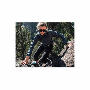 Person wearing Under Armour jacket and sunglasses climbing a rocky trail