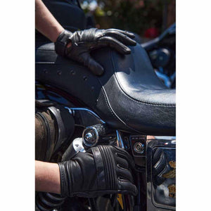 Milwaukee Leather black motorcycle gloves resting on a leather motorcycle seat