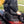 Person sitting on an Alpcour black portable stadium seat on a metal bleacher