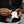 Hands inserting a white cooling pack into a black fabric pocket on a vest