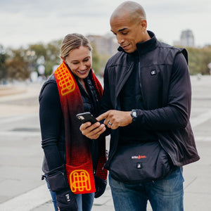 Man and woman wearing ActionHeat heated apparel while looking at a smartphone