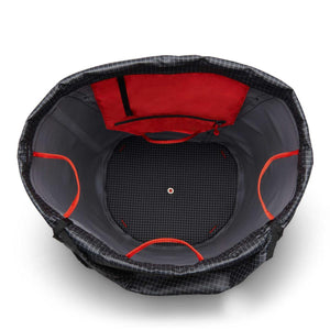 Interior view of a black grid pattern backpack with a red zippered pocket and red internal loops