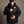 Man wearing a black Green Bay Packers hooded puffer jacket with team logo on chest
