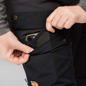 Close up of FjallRaven trousers showing a hand placing a smartphone into a buttoned leg pocket