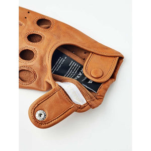 Tan leather driving glove with snap button closure and care label