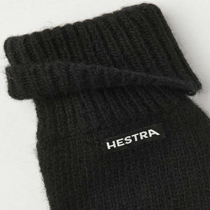 Black Hestra knit glove cuff with ribbed texture and brand label