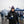 Man wearing New England Patriots beanie and jacket holding a coffee cup at a tailgate party
