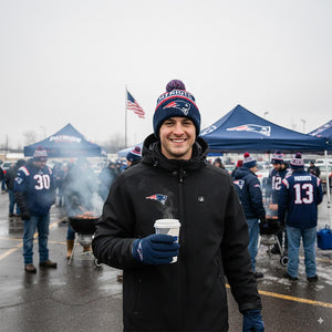 Man wearing New England Patriots beanie and jacket holding a coffee cup at a tailgate party