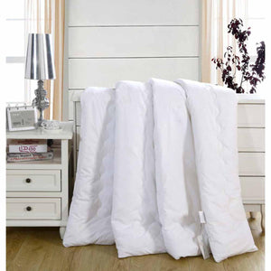 HealthyLine white quilted comforter folded on a white bedside table