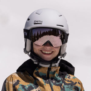 Person wearing a white Smith Optics helmet and mirrored ski goggles
