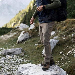 Person wearing FjallRaven hiking trousers and boots standing on a rocky mountain trail