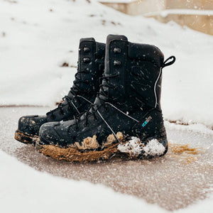Black Icebite waterproof work boots covered in mud and snow