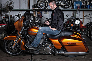 Man sitting on a copper Harley Davidson motorcycle wearing a Gerbing heated jacket